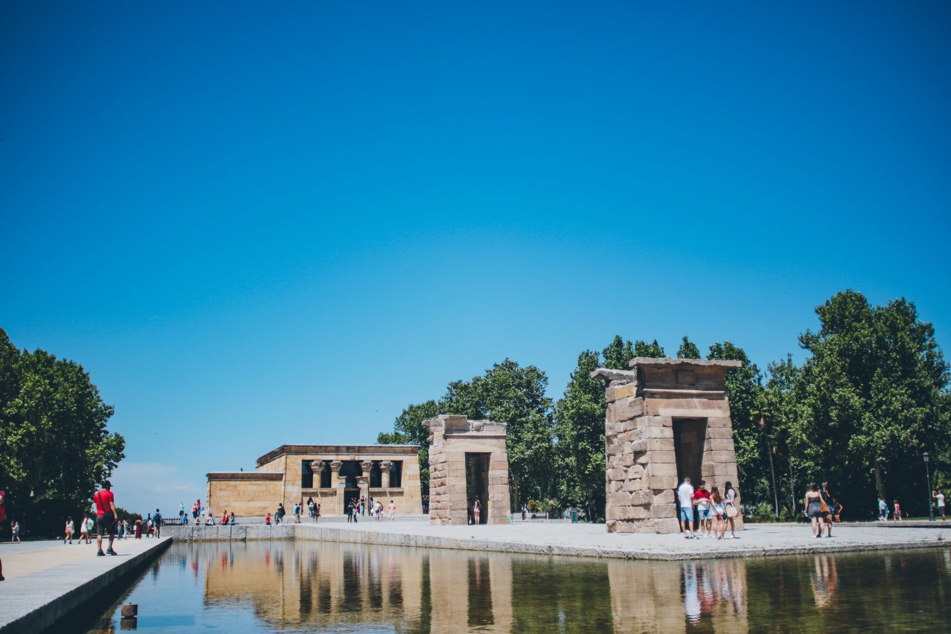 Beautiful view of the Temple of Debod in Madrid, España, under a clear blue sky, with reflections in the water